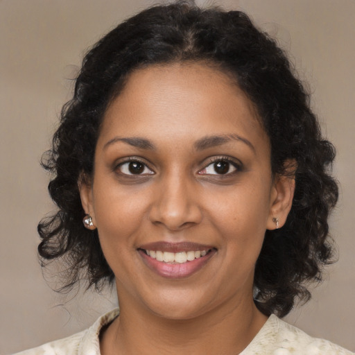 Joyful black young-adult female with medium  brown hair and brown eyes