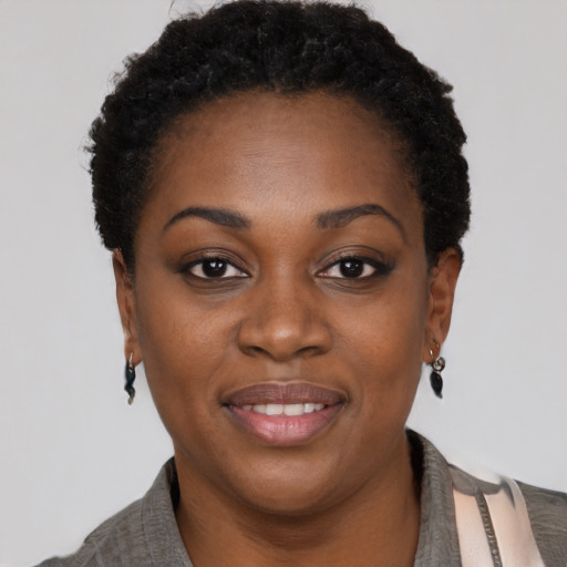 Joyful black young-adult female with short  black hair and brown eyes