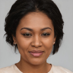 Joyful black adult female with medium  brown hair and brown eyes