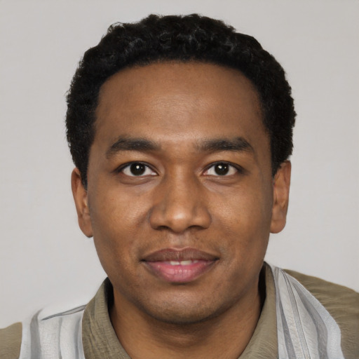 Joyful black young-adult male with short  black hair and brown eyes