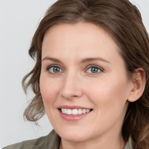 Joyful white young-adult female with long  brown hair and blue eyes