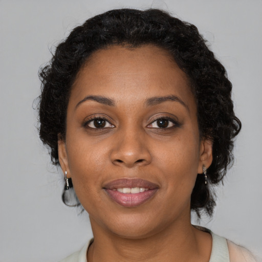 Joyful black adult female with medium  brown hair and brown eyes