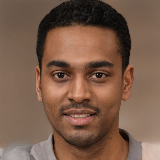 Joyful black young-adult male with short  black hair and brown eyes