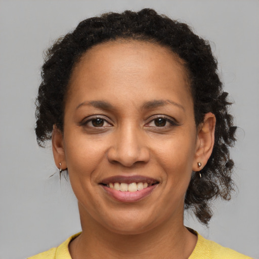 Joyful black young-adult female with medium  brown hair and brown eyes