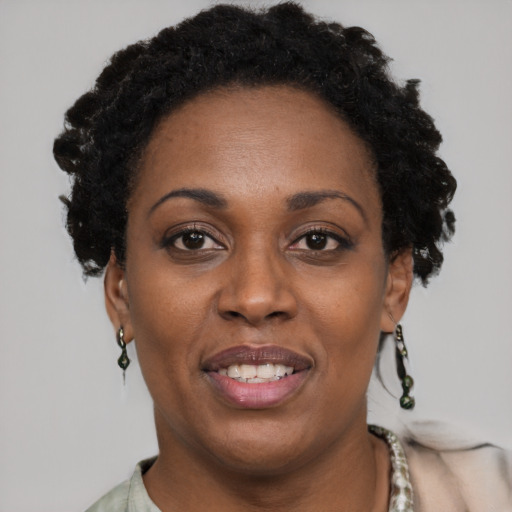 Joyful black adult female with short  black hair and brown eyes