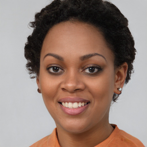 Joyful black young-adult female with short  brown hair and brown eyes