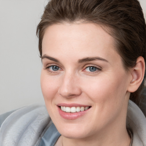 Joyful white young-adult female with short  brown hair and blue eyes