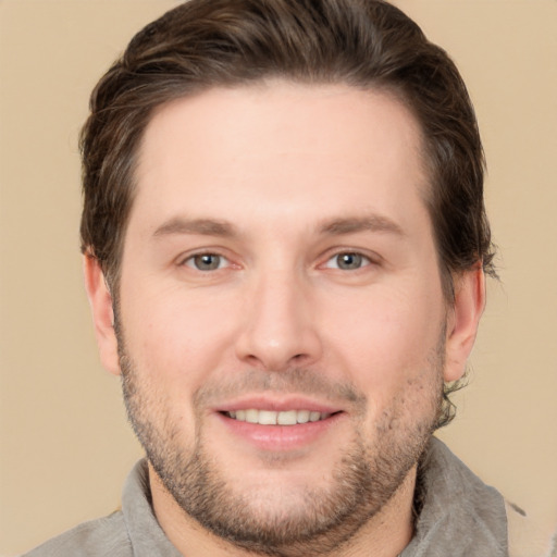 Joyful white young-adult male with short  brown hair and grey eyes