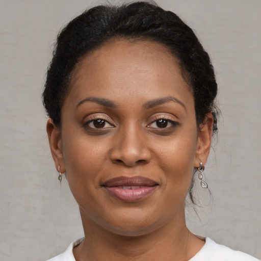 Joyful black young-adult female with short  brown hair and brown eyes