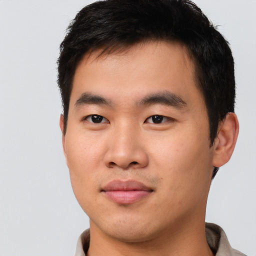 Joyful asian young-adult male with short  black hair and brown eyes