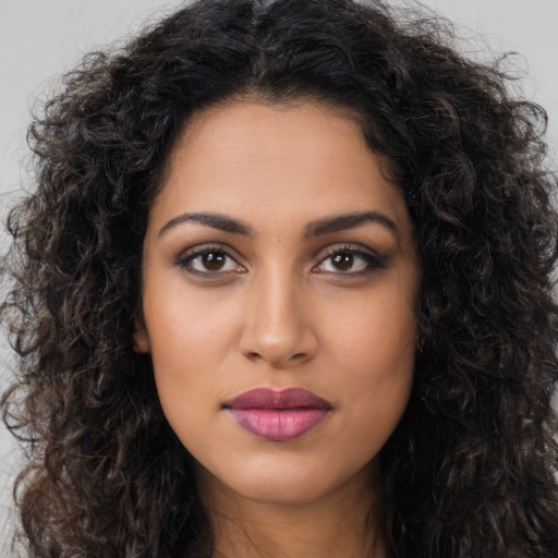 Joyful latino young-adult female with long  brown hair and brown eyes