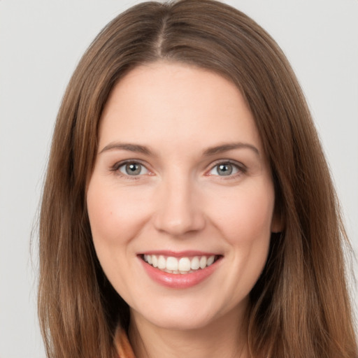 Joyful white young-adult female with long  brown hair and grey eyes