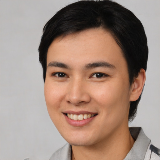 Joyful asian young-adult male with short  brown hair and brown eyes
