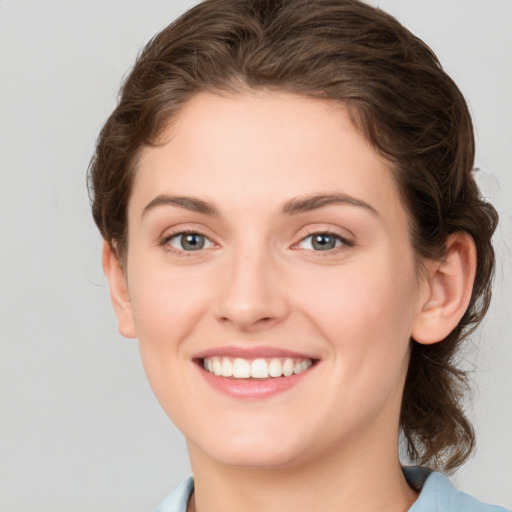 Joyful white young-adult female with medium  brown hair and green eyes