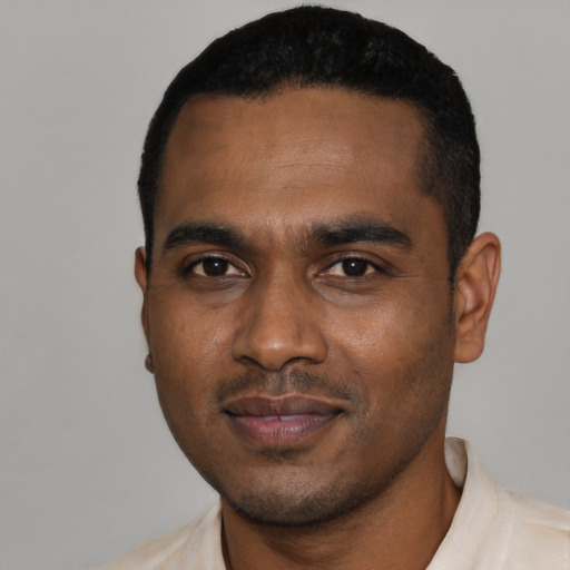 Joyful black young-adult male with short  black hair and brown eyes