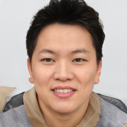 Joyful asian young-adult male with short  brown hair and brown eyes