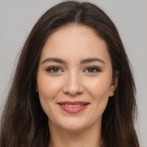 Joyful white young-adult female with long  brown hair and brown eyes