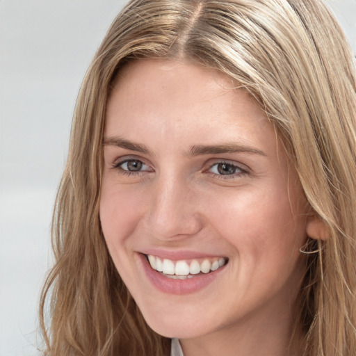 Joyful white young-adult female with long  brown hair and blue eyes