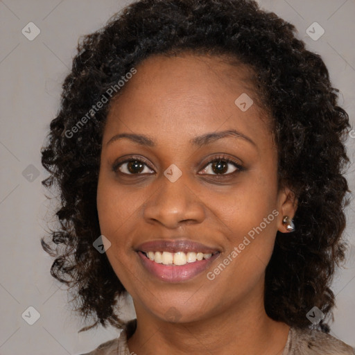 Joyful black young-adult female with long  brown hair and brown eyes