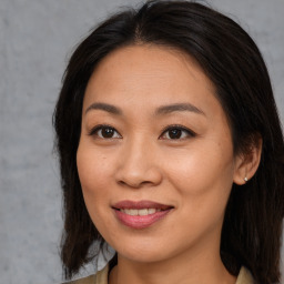 Joyful asian young-adult female with long  brown hair and brown eyes