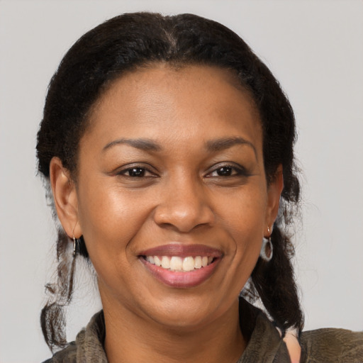 Joyful black adult female with medium  brown hair and brown eyes