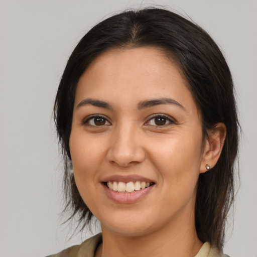 Joyful latino young-adult female with medium  brown hair and brown eyes