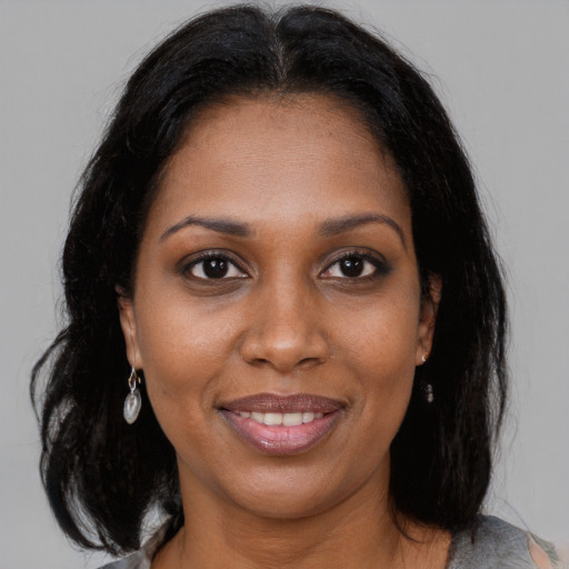 Joyful black adult female with medium  brown hair and brown eyes