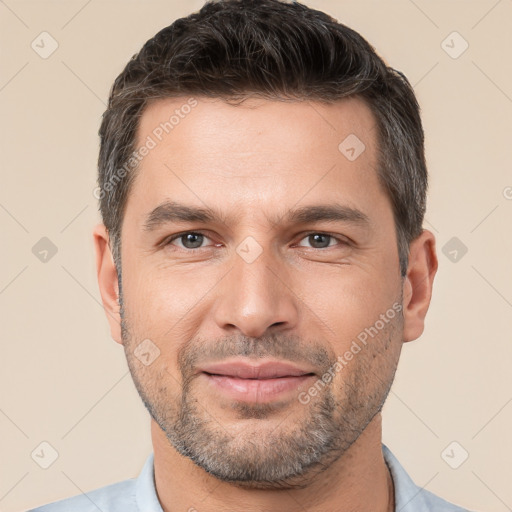 Joyful white young-adult male with short  brown hair and brown eyes