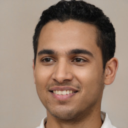 Joyful latino young-adult male with short  black hair and brown eyes