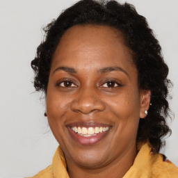 Joyful black adult female with medium  brown hair and brown eyes