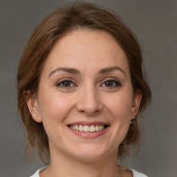 Joyful white adult female with medium  brown hair and grey eyes