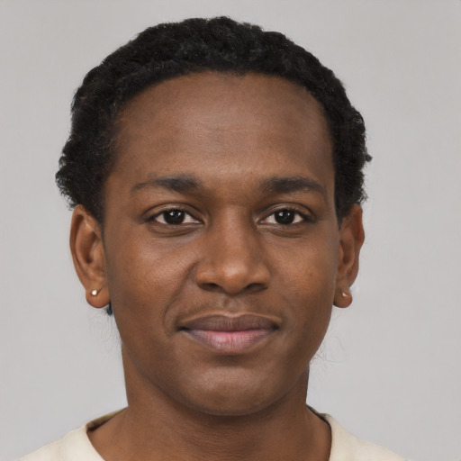 Joyful black young-adult male with short  black hair and brown eyes