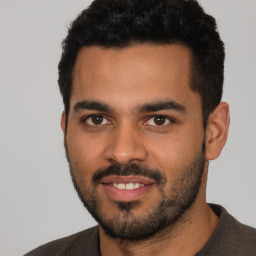 Joyful latino young-adult male with short  black hair and brown eyes