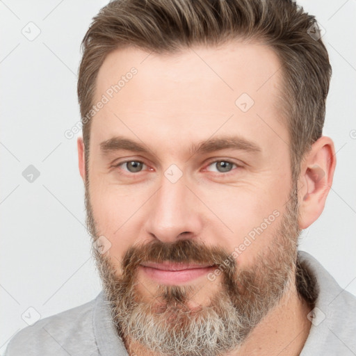 Joyful white adult male with short  brown hair and brown eyes