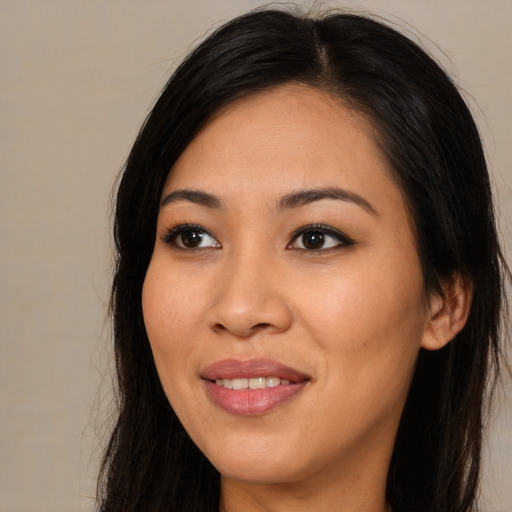 Joyful asian young-adult female with long  brown hair and brown eyes