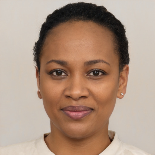 Joyful black young-adult female with short  black hair and brown eyes