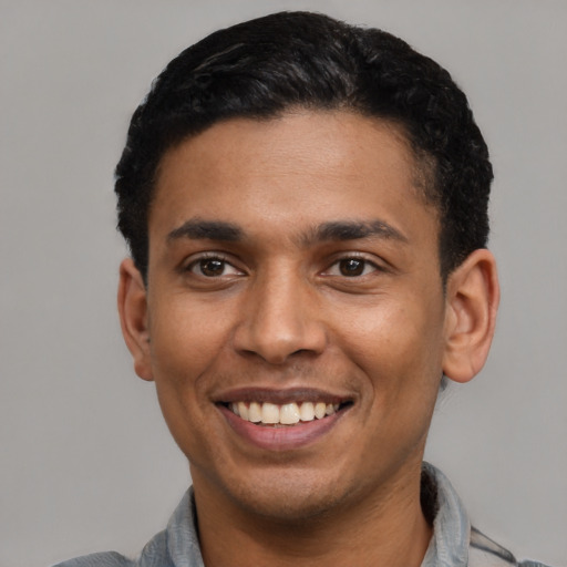 Joyful latino young-adult male with short  black hair and brown eyes