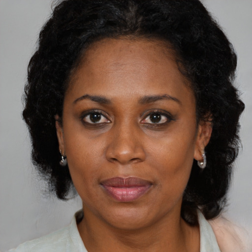 Joyful black adult female with medium  black hair and brown eyes