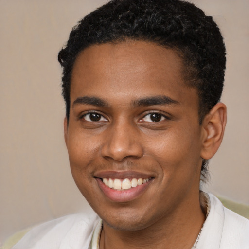 Joyful black young-adult male with short  brown hair and brown eyes