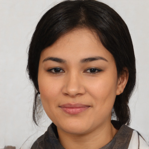 Joyful latino young-adult female with medium  black hair and brown eyes