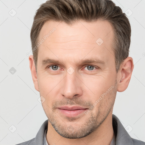 Joyful white young-adult male with short  brown hair and grey eyes