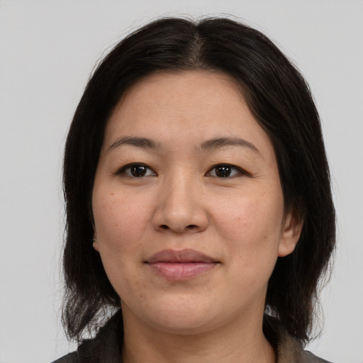 Joyful asian adult female with medium  brown hair and brown eyes