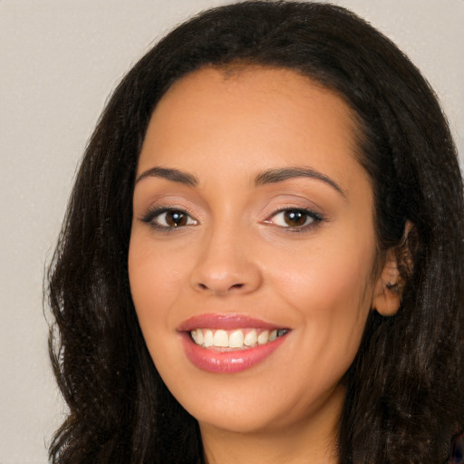 Joyful latino young-adult female with long  brown hair and brown eyes