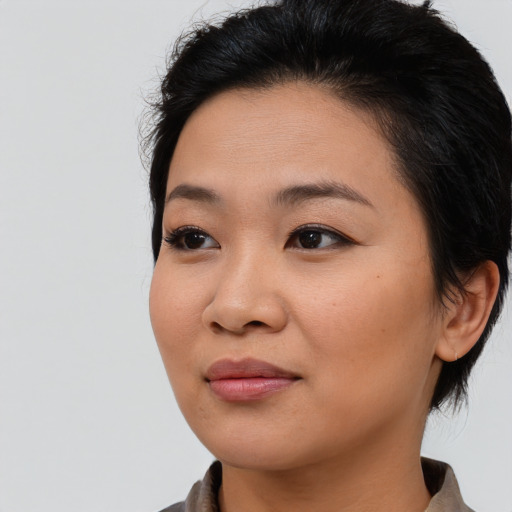 Joyful asian young-adult female with medium  brown hair and brown eyes