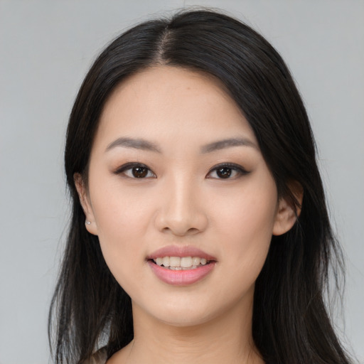 Joyful asian young-adult female with long  black hair and brown eyes