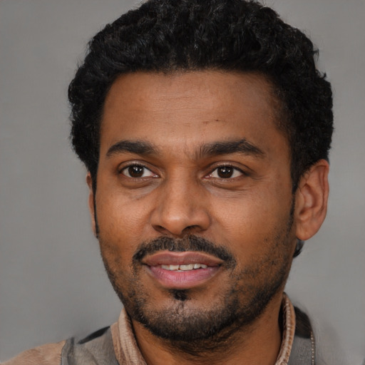 Joyful black young-adult male with short  black hair and brown eyes
