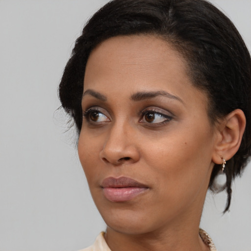 Joyful black young-adult female with medium  brown hair and brown eyes