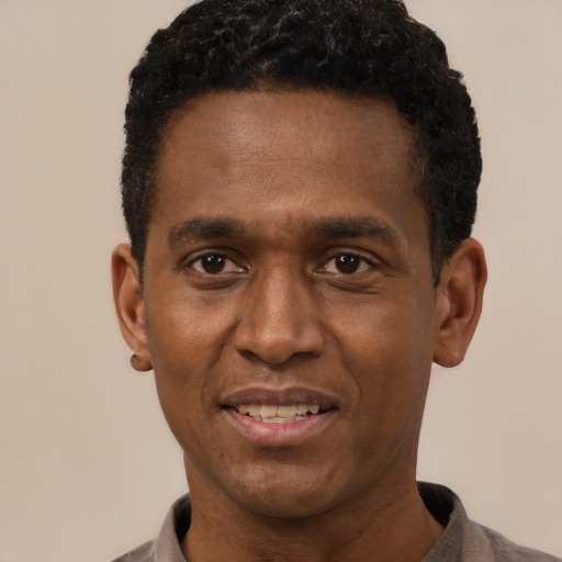 Joyful black adult male with short  black hair and brown eyes