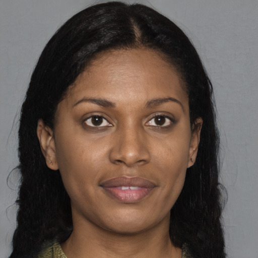 Joyful black adult female with long  brown hair and brown eyes