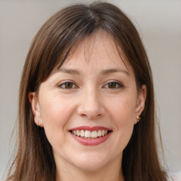 Joyful white young-adult female with long  brown hair and brown eyes